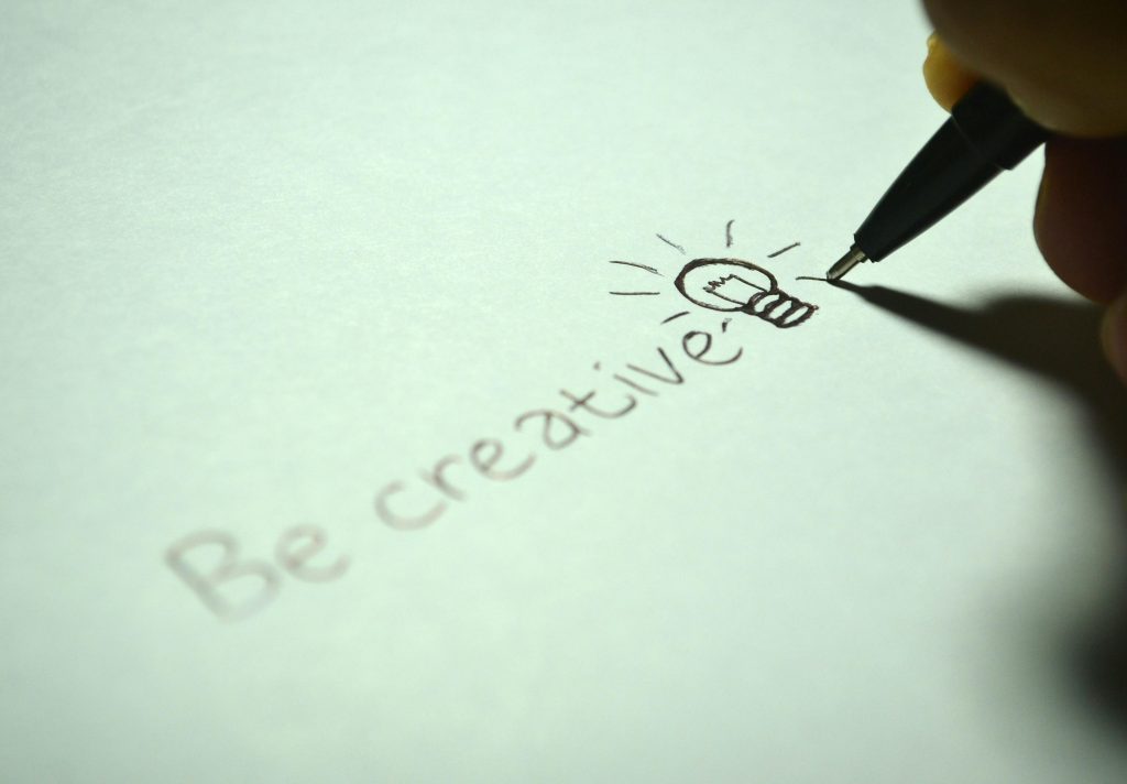 the phrase, "be creative" written with a light bulb drawing