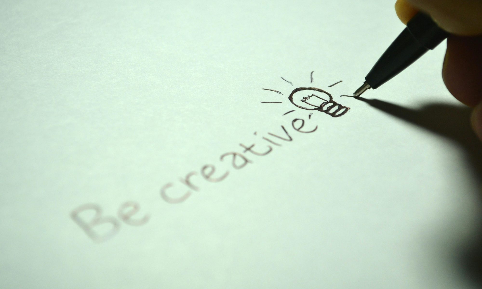 the phrase, "be creative" written with a light bulb drawing