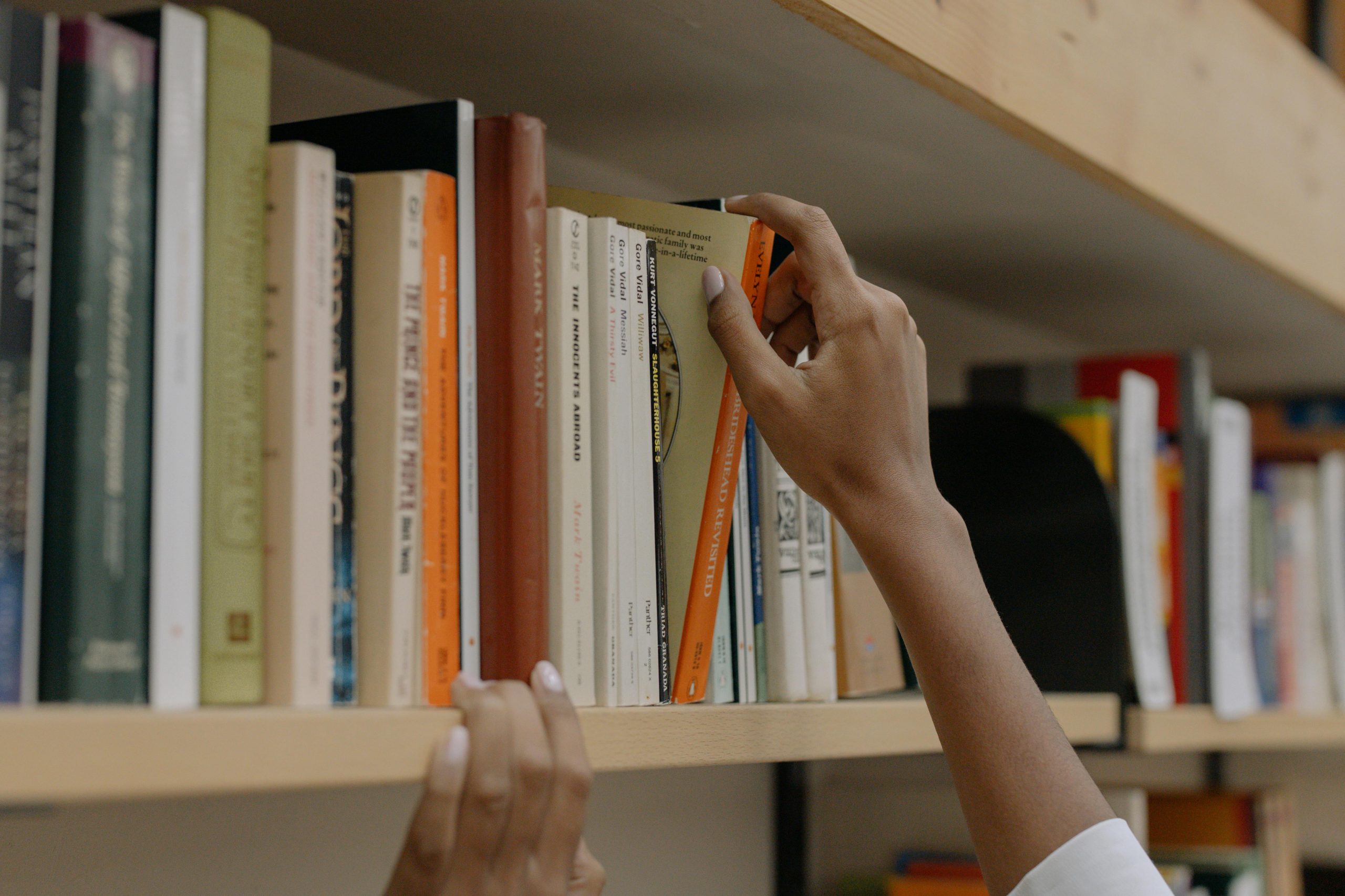 Someone selects a book from a row of options