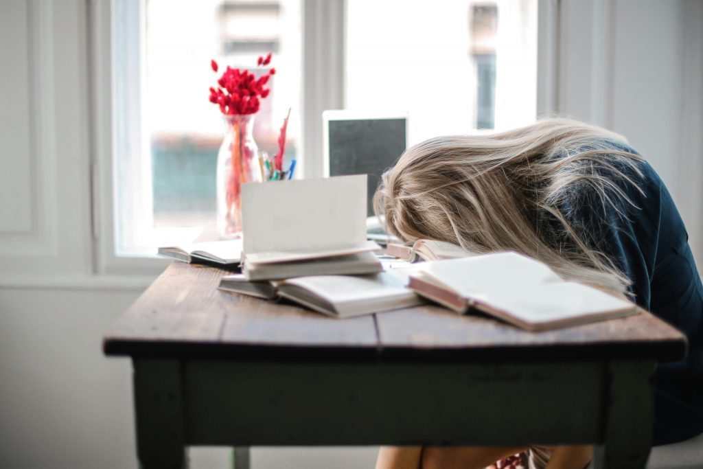 burnt out student with head down on desk