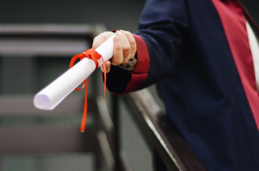 graduate holding their diploma